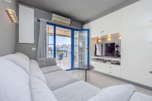 a living room with a white couch and a tv at Atalaya 2 Sea View - Puerto del Carmen in Tías
