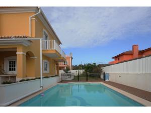 a swimming pool in the backyard of a house at Villa dos Teixos in Cascais