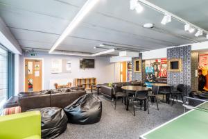 a waiting room with couches and tables and chairs at Destiny Student – Murano (Campus Accommodation) in Edinburgh