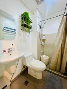 ein weißes Badezimmer mit Toilette und Waschbecken in der Unterkunft Peaceful Studio Unit at Centrio Tower beside Ayala Mall in Cagayan de Oro