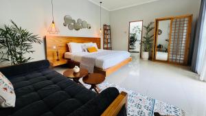 ein Schlafzimmer mit einem Bett und einer Couch in der Unterkunft Villa Voyage 5 in Seminyak