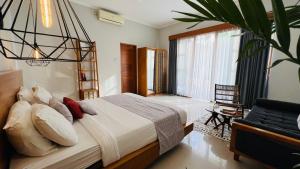 ein Schlafzimmer mit einem Bett und einem großen Fenster in der Unterkunft Villa Voyage 5 in Seminyak