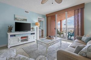a living room with a tv and a couch and a table at Buena Vista 205 in Gulf Shores
