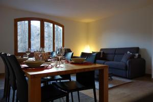 a dining room with a table with chairs and a couch at Chesa Muragls in Pontresina