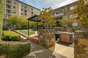 Un jardín con parrilla al aire libre en un edificio. en Stylish Canberra Stay -Sauna ,Pool ,Gym,Balcony, en Canberra