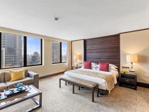 a bedroom with a large bed and a couch at Mandarin Oriental, Jakarta in Jakarta