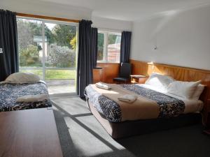 a hotel room with two beds and a window at Otaki Motel in Otaki