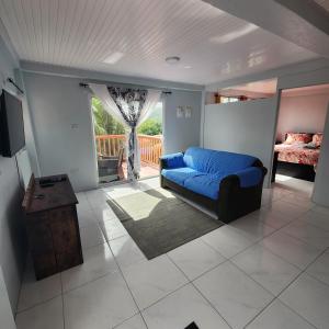 a living room with a blue couch and a balcony at flamboyantvilla in Gros Islet