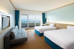 a hotel room with two beds and a window at Saipan World Resort in Susupe