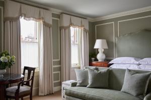 a bedroom with a bed and a couch and a table at Egerton House in London