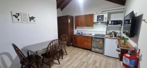 a kitchen with a table and chairs and a stove and refrigerator at Depto Laguna Encantada in Ushuaia