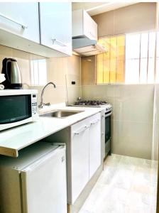 une cuisine avec un évier et un micro-ondes dans l'établissement Limaportofino, à Lima