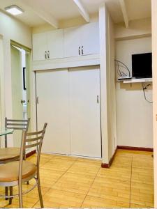 Cette chambre comprend une table, des chaises et des armoires blanches. dans l'établissement Limaportofino, à Lima