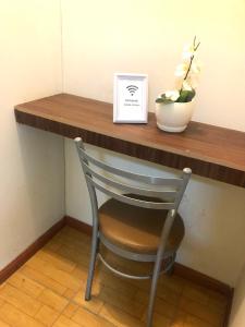 une chaise assise sous un bureau avec un vase de fleurs dans l'établissement Limaportofino, à Lima