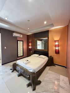a bedroom with a large bed and a mirror at Topinn Hotel in Ban Lat Krachaeng +15 photos
