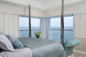 a bedroom with a bed with a view of the ocean at Twelve Apostles Hotel & Spa in Cape Town