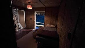 a dark room with a bed and a window at Chakerpor bamboo house 2 in Ban Yang Huai Tong