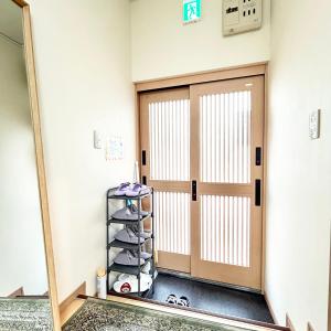 a room with a door and a rack of towels at 西九条駅徒歩2分USJと梅田と関空直通丸々貸切長屋koto in Osaka