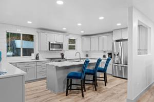 a kitchen with white cabinets and blue chairs at Ski Lover's Paradise- 7BR Villa Near Top Resorts home in Holladay