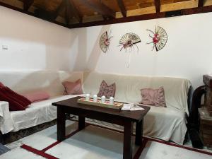 a living room with a white couch and a table at Casa Lily - Japanese Retreat in Sighişoara