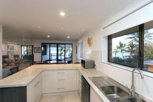 a kitchen with a sink and a large window at Horizons Unit 4 Beachfront Unit in Bargara