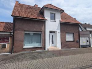 a white and brown house with a red roof at Feeling in Hamm