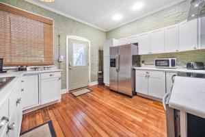 cocina con armarios blancos y suelo de madera en Urban Oasis Haven in St Catherine, en Louisville
