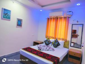 a bedroom with a bed with an orange curtain at S3 Beach Resort in Pondicherry