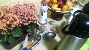 a counter top with flowers and a bowl of fruit at Pousada Enseada das Conchas in Ilha do Mel