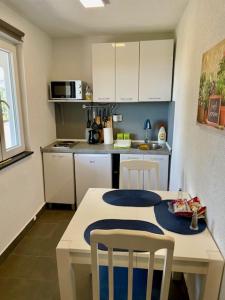 eine kleine Küche mit einem Tisch und zwei Stühlen in der Unterkunft Sutomore Panorama Apartment in Sutomore