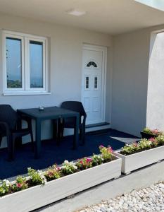 eine Veranda mit einem Tisch und zwei Stühlen und Blumen in der Unterkunft Sutomore Panorama Apartment in Sutomore