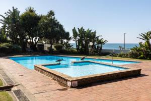 ein Schwimmbad mit zwei Delfinen im Wasser in der Unterkunft Laguna La Crete 12 in Uvongo Beach