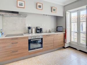 Una cocina con gabinetes de madera y un horno de estufa. en Apartment Carcasses, en Carcassonne 21 fotos más