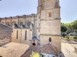 un gran edificio de ladrillo con una torre en la parte superior en Apartment Carcasses, en Carcassonne