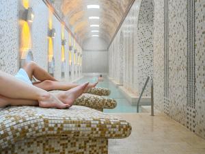 a person laying on a couch in a swimming pool at Hotel Termas Balneario Termas Pallares in Alhama de Aragón