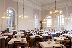 a large banquet hall with tables and chairs and chandeliers at Hotel Termas Balneario Termas Pallares in Alhama de Aragón