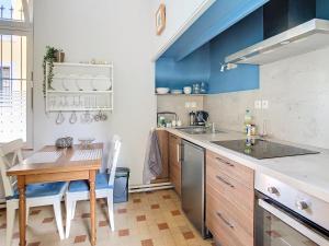 カルカソンヌにあるApartment Jeanneの青い壁のキッチン(木製テーブル付) +18枚の写真