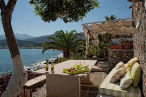 a table with a bowl of fruit on it next to the water at Skajado Holiday Apartments in Stalís