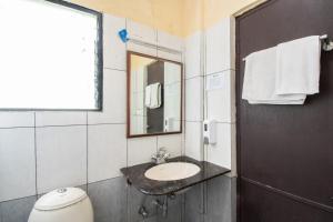 un bagno con lavandino, specchio e WC di Chocolat house a Bangalore