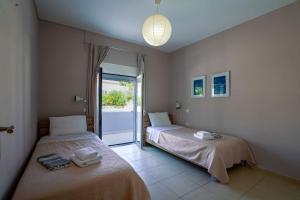 two beds in a room with a window at Villa SteMMa in Chania Town +16 photos