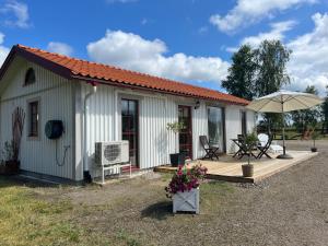 a small house with a deck and an umbrella at Brittas Country House in Munka-Ljungby