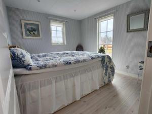 a bedroom with a bed in a room with windows at Brittas Country House in Munka-Ljungby