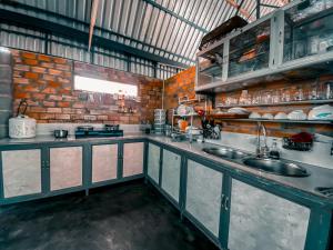 una cucina con lavandino e muro di mattoni di Gem’s House a Mui Ne