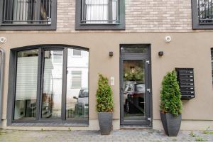 a building with two plants in front of a door at Hales Old Town Urban Apartments in Vilnius