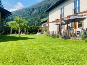 a house with a yard with an umbrella at Mallnbach Apartments in Mallnitz