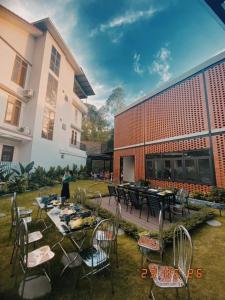 a group of tables and chairs in front of a building at Chuỗi Villa 7 ngủ - tuần Châu - Bể bơi riêng - BBQ - Đầy đủ tiện nghi in Ha Long