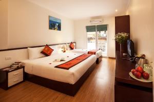 a hotel room with two beds and a television at Rising Dragon Hotel in Hanoi