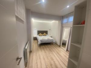 a small bedroom with a bed and a mirror at ENCANTO CUENCA Balcones De La Historia in Cuenca
