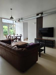 a living room with a couch and a table at Troglodyte Baths natural coolness in Saint-Étienne-de-Chigny