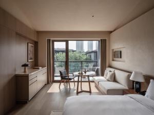 西安西安央辰酒店 Younch Hotel Xi'an的一间卧室配有一张床、一张桌子和一张沙发 更多37张照片